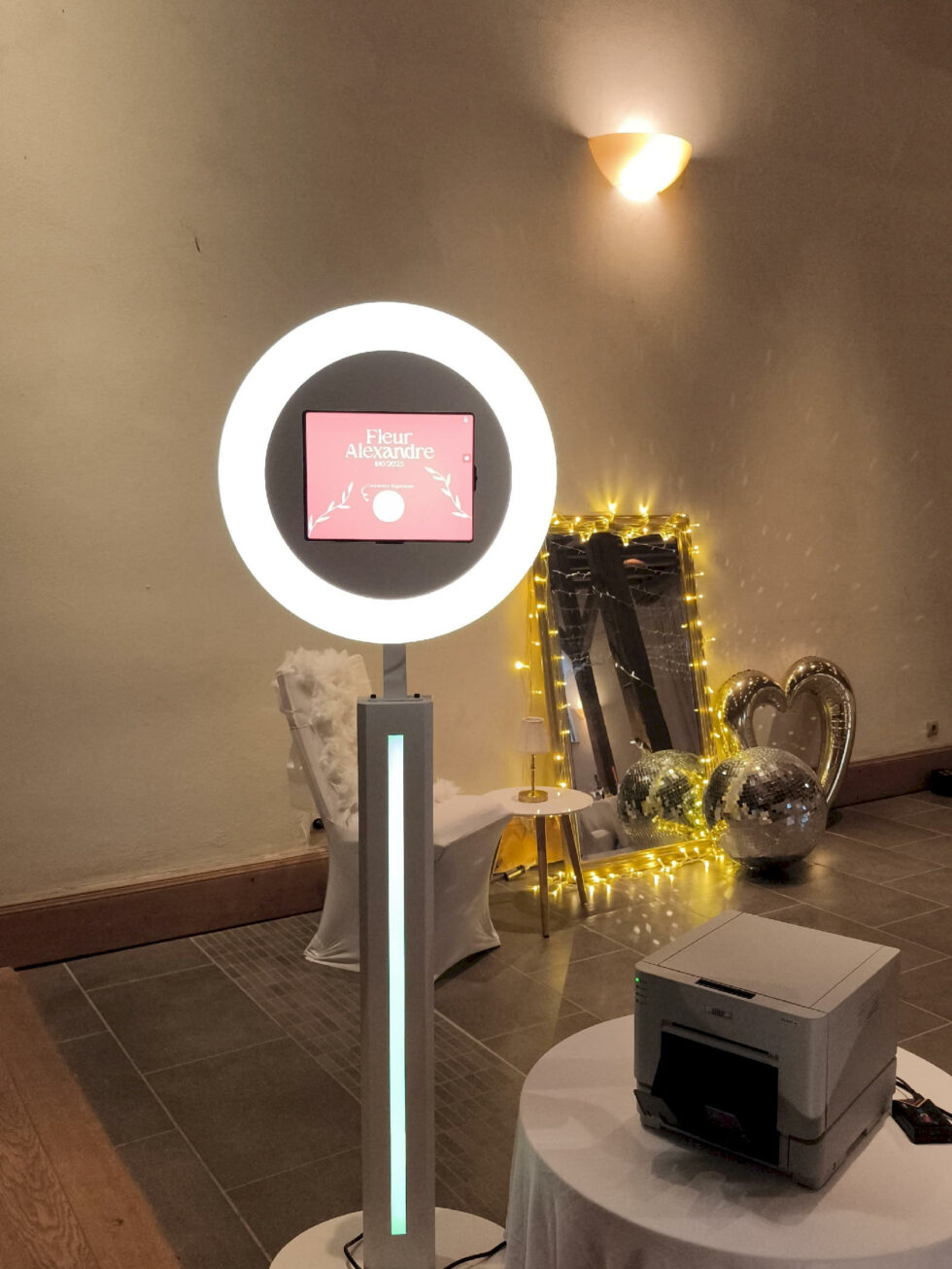 Borne photobooth installée avec miroir lumineux et accessoires pour animation photo de mariage