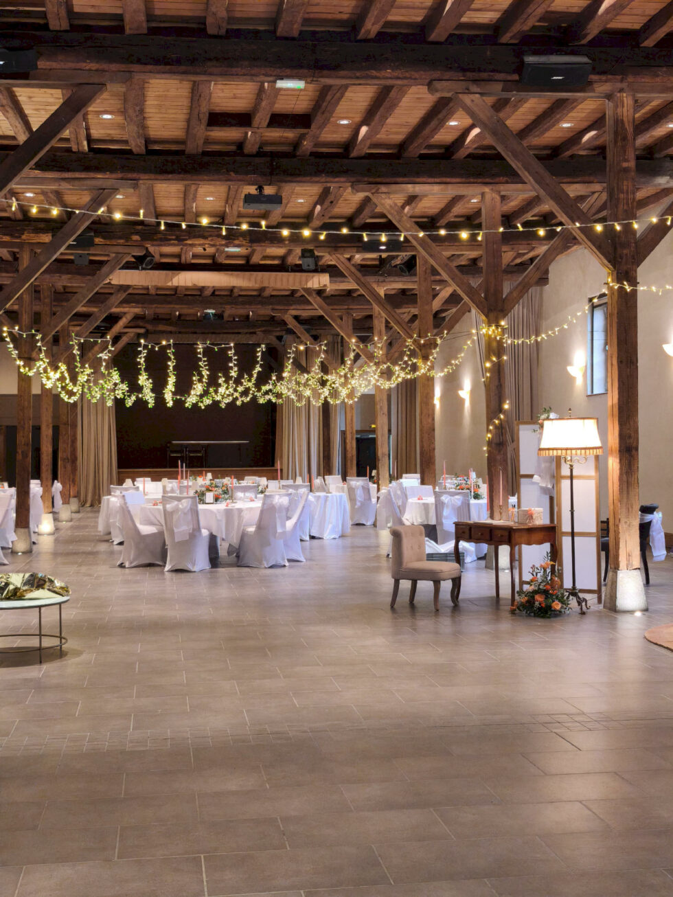Composition florale colorée sur tonneau avec plan de table pour réception de mariage