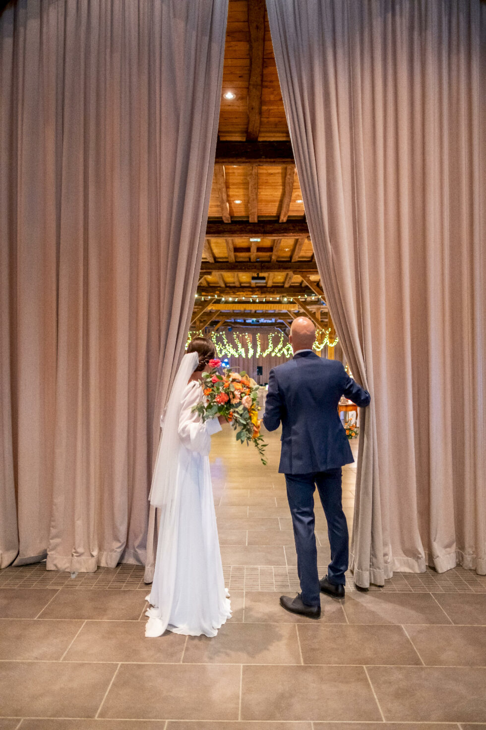 Entrée des mariés dans une salle décorée avec rideaux et mise en ambiance lumineuse