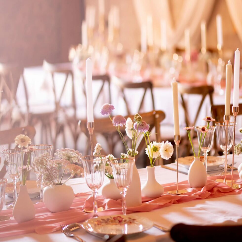 Table de mariage pastel avec bougies, fleurs et verres pour réception élégante