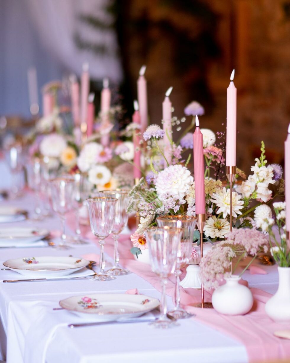 Décoration de table mariage avec composition florale pastel et bougies roses ambiance romantique