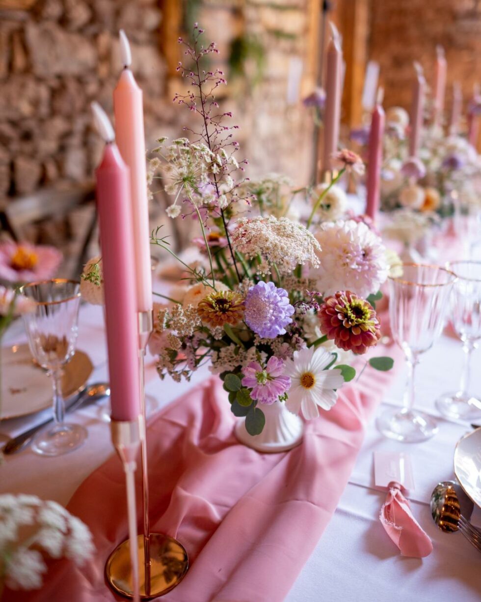 Détail décoration mariage romantique avec fleurs délicates et bougies roses ambiance douce