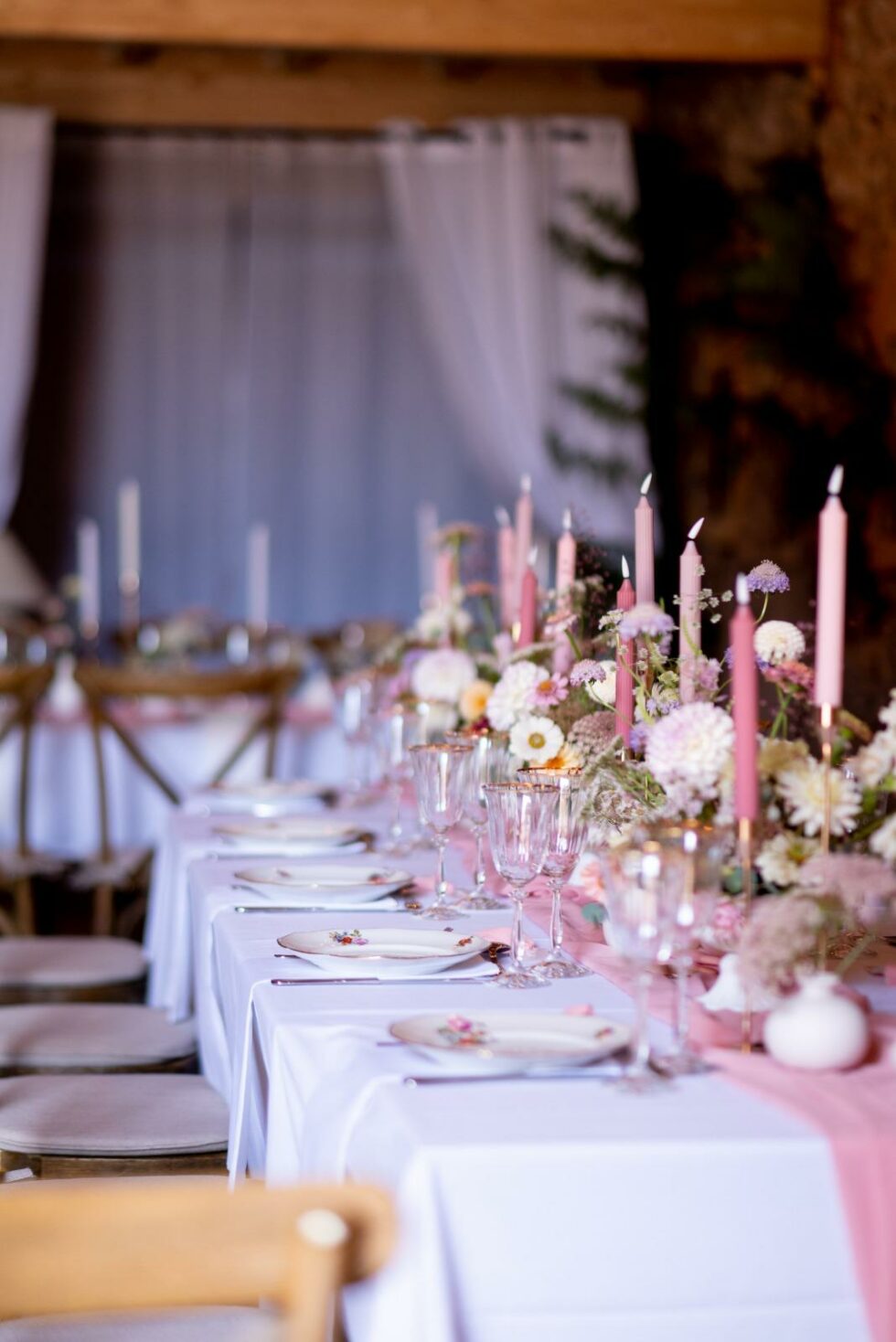 Table de mariage élégante avec chemin de table rose bougies et décoration florale pastel
